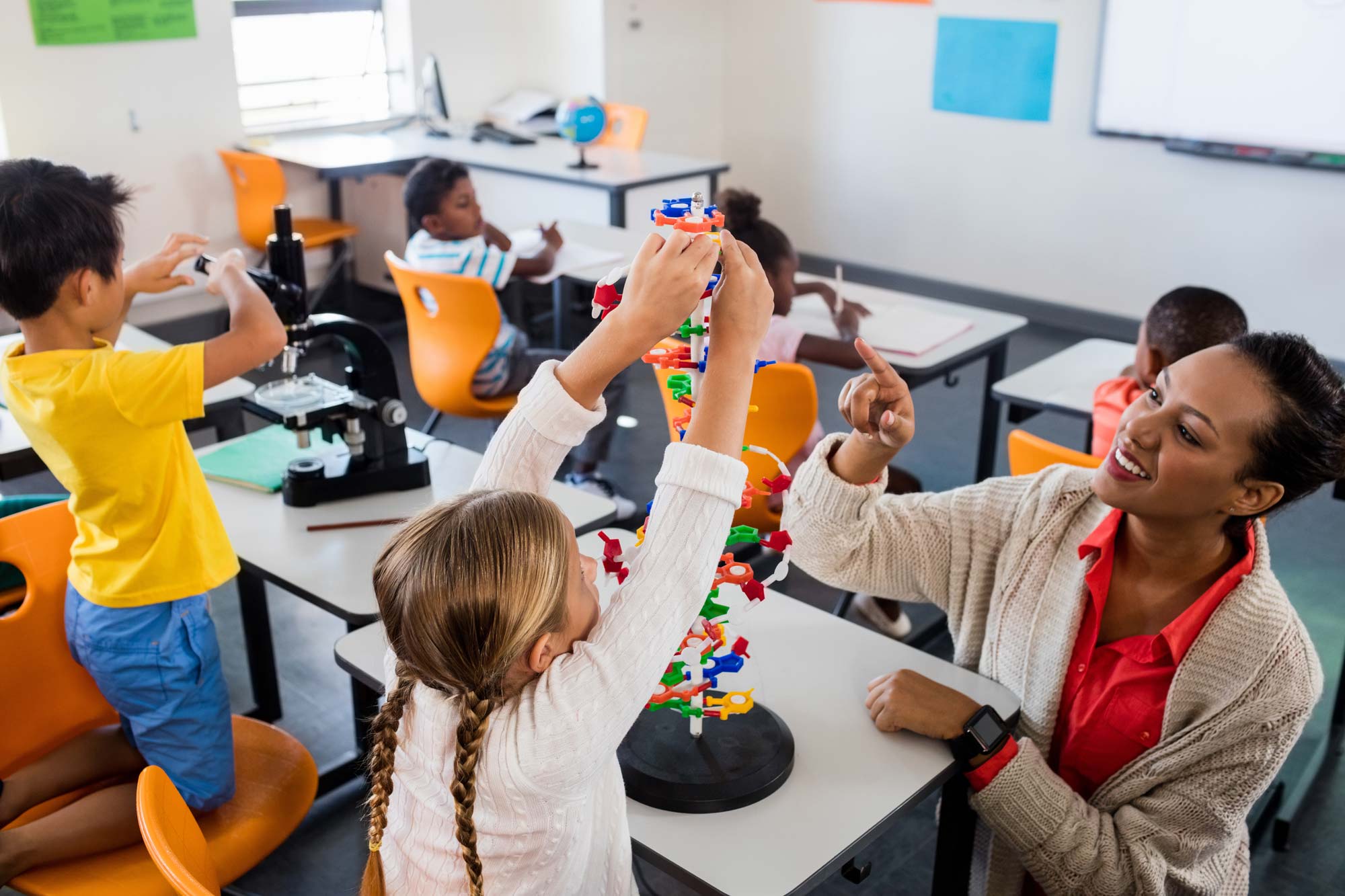 Young students in classroom participating in activity with teacher